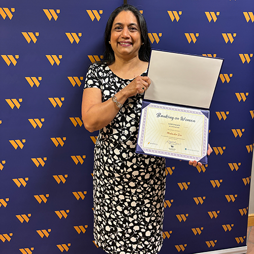 Person standing holding a diploma